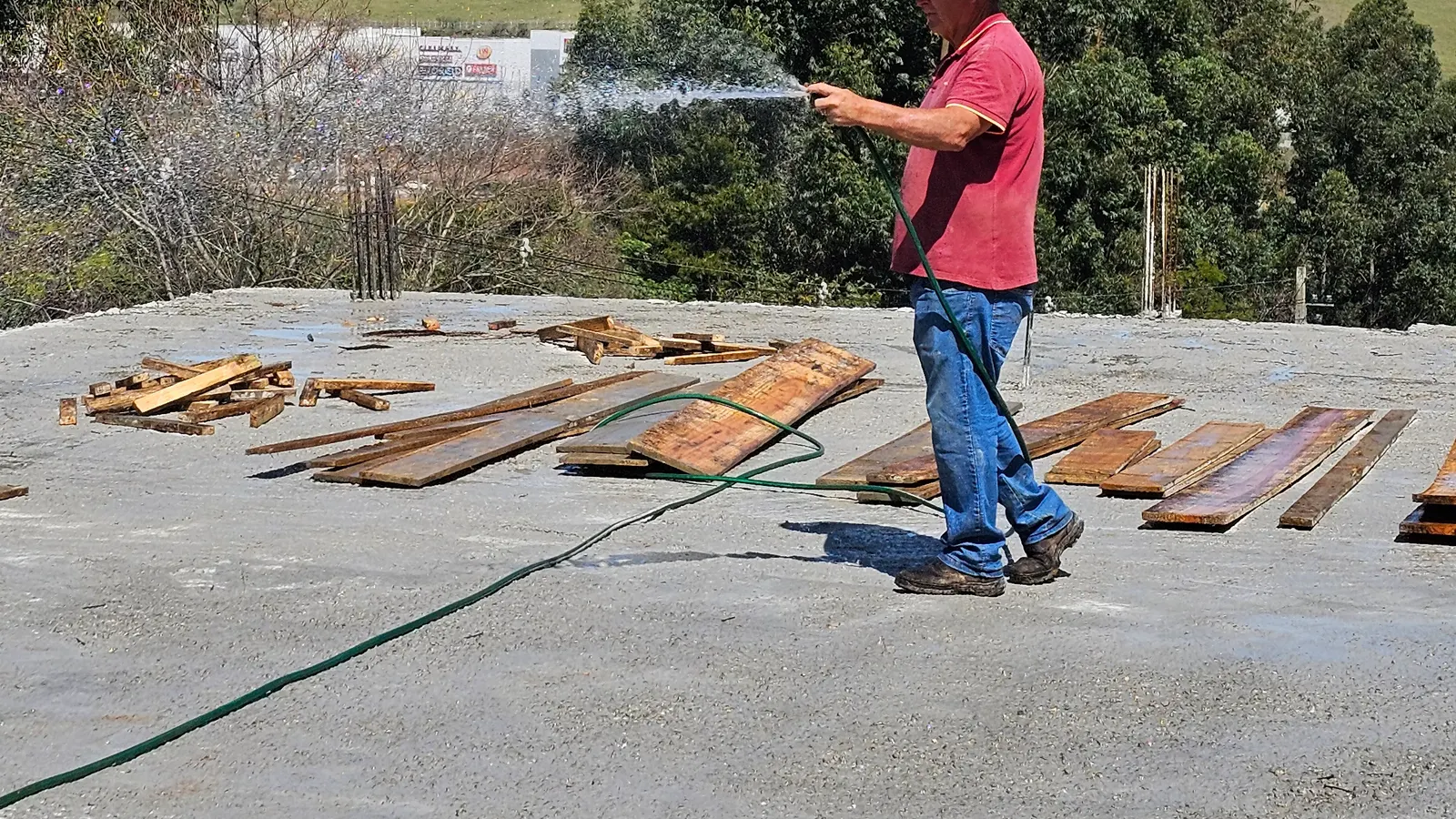 Colaborador da Avant Garde molhando a laje recém-concretada